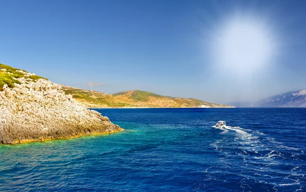 Barcos de motor con roca alta contra el mar azul y el cielo azul en Zakynthos.Motor barco desaparecido Isla de Zakynthos en Grecia.Crucero motorizado en el mar azul de la isla en Grecia . —  Fotos de Stock
