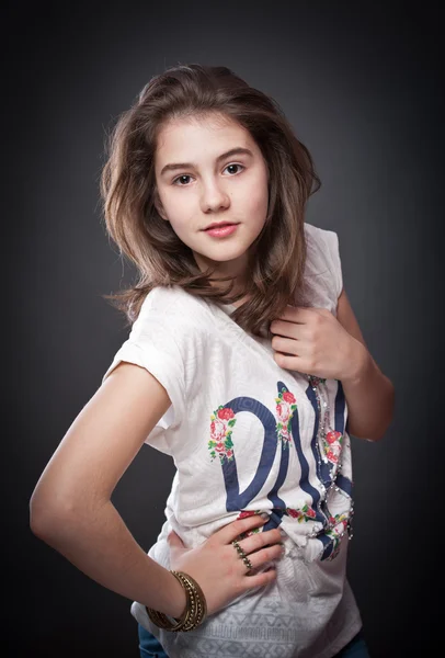 Hermosa chica adolescente con el pelo largo y liso, posando sobre el fondo.Retrato de una hermosa adolescente con largos pelos rizados —  Fotos de Stock