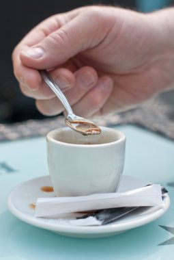 fincan kahve ve spoon.man ile el şeker kahve bir fincan içinde karıştırın..