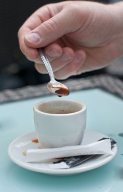 kahve kaşık tutan bir el ile cam tabloda