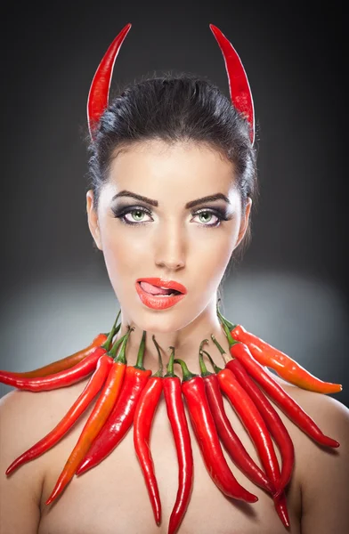 Krásná mladá žena portrét s červeným teplé a pikantní papričky, modelka s kreativní jídla zeleniny tvoří strany chtějí prázdné kopie prostoru, izolované černém pozadí. červená chili paprika. — Stock fotografie