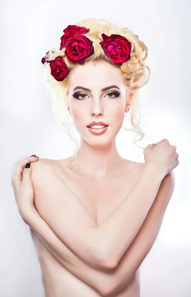 Hairstyle - beautiful sexy female art portrait with roses.Elegance. Genuine Natural Blonde Bride with red Flowers. Artistry.Portrait of a beautiful blonde woman with flowers in her hair. Fashion photo — Stock Photo, Image