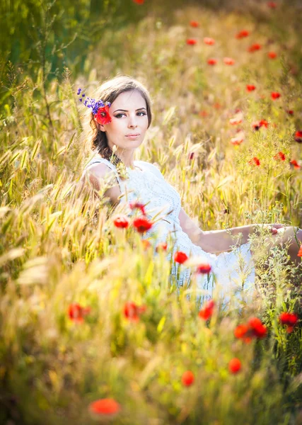 Jovem no campo de trigo dourado.Retrato de menina loira bonita com coroa de flores silvestres.Mulher bonita desfrutando de campo de margarida, menina bonita relaxante ao ar livre, conceito de harmonia . — Fotografia de Stock