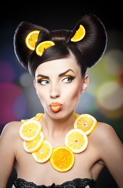 Belle fille avec des tranches de citron comme necklace.Portrait d'une femme avec des oranges comme accessoires. Modèle de mode avec maquillage créatif de légumes alimentaires.Femme sensuelle avec maquillage de luxe et coiffure — Photo