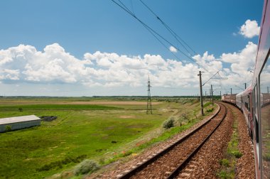 Yaz ve beyaz bulutlar ile mavi gökyüzü bulutlu sky.scenic demiryolu kırsal alanda altında beyaz clouds.railway ile yeşil ve sarı manzara mavi gökyüzünün altında horizont demiryolu gider.