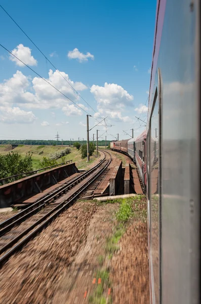 Railway goes to horizont in green and yellow landscape under blue sky with white clouds.railway under cloudy sky.Scenic railroad in rural area in summer and blue sky with white clouds. — Stock Photo, Image