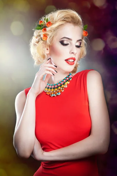 Sexy blond kobieta w czerwonej sukience .hairstyle - piękny portret kobiety sztuka z roses.elegance. prawdziwy naturalny blond z czerwonych kwiatów. portret pięknej kobiety blondynka z kwiatami we włosach. — Zdjęcie stockowe