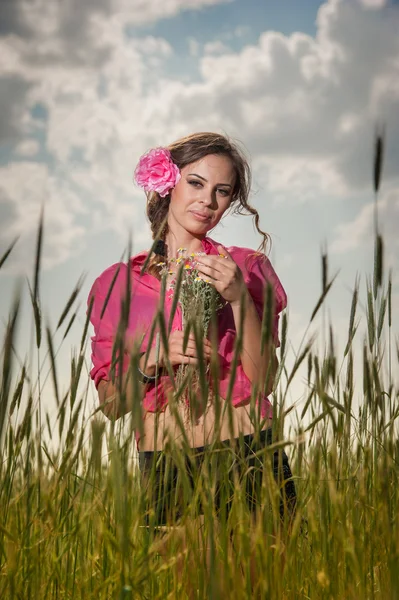 Jovem no campo de trigo dourado.Retrato de menina loira bonita com coroa de flores silvestres.Mulher bonita desfrutando de campo de margarida, menina bonita relaxante ao ar livre, conceito de harmonia . — Fotografia de Stock