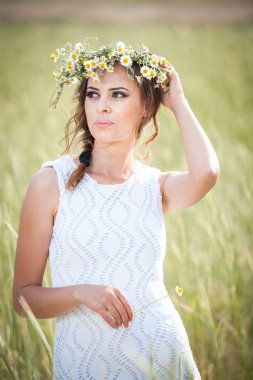 güzel kızın rahatlatıcı açık, harmony kavram vahşi flowers.beautiful kadın zevk papatya alan, çelenk ile altın buğday field.portrait güzel sarışın kızın üzerinde çelenk ile genç kız