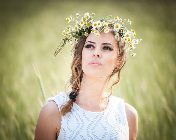 Jeune fille avec couronne sur le champ de blé doré. Portrait de belle fille blonde avec couronne de fleurs sauvages. Belle femme appréciant le champ de marguerite, jolie fille relaxante en plein air, concept d'harmonie. — Photo