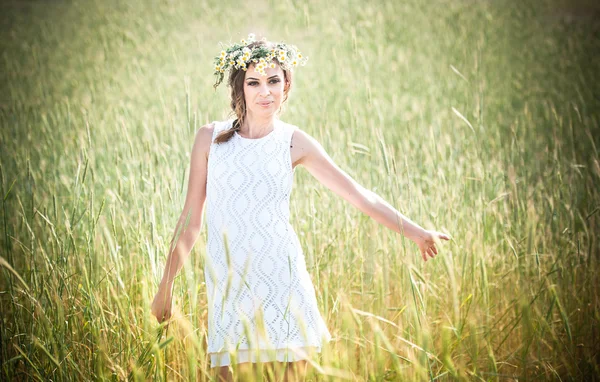 Jeune fille avec couronne sur le champ de blé doré. Portrait de belle fille blonde avec couronne de fleurs sauvages. Belle femme appréciant le champ de marguerite, jolie fille relaxante en plein air, concept d'harmonie. — Photo