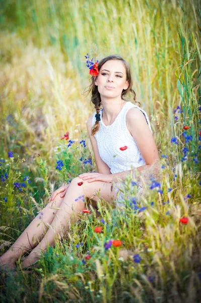 Jovem no campo de trigo dourado.Retrato de menina loira bonita com coroa de flores silvestres.Mulher bonita desfrutando de campo de margarida, menina bonita relaxante ao ar livre, conceito de harmonia — Fotografia de Stock