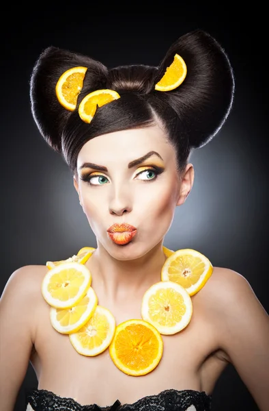 Beautiful girl with slices lemon as neck less.Portrait of a woman with oranges as a accessories. Fashion model with creative food vegetable make-up .Sensual woman with luxury makeup and hair style — Stock Photo, Image