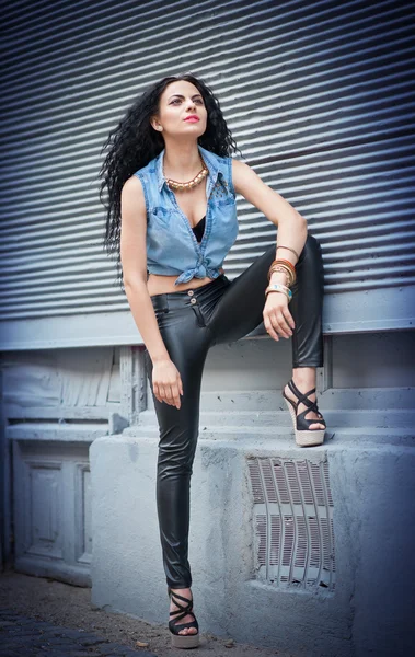 Jolie femme en cuir noir pantalon et chemise posant dans la rue.Beauté aux cheveux longs avec un corps magnifique en cuir noir pantalon dans la ville — Photo