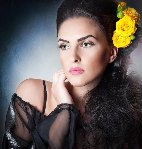 Peinado y maquillaje hermoso retrato de arte femenino con rosas amarillas. Elegancia. Genuina morena natural con flores. Retrato de una mujer atractiva con hermosos ojos y flores en el pelo . —  Fotos de Stock