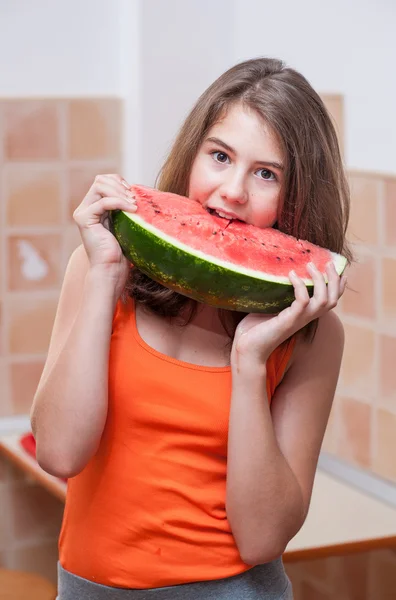 Beautiful teen girl with slice of fresh watermelon .Young girl eating watermelon.Portrait of teenage girl in red t-shirt and long hair holding watermelon slice in the chicken — Stock Photo, Image