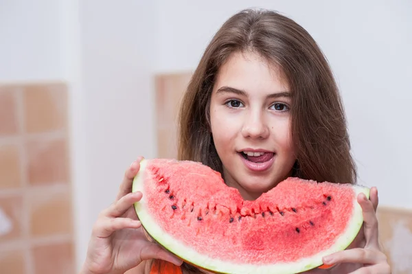 Beautiful teen girl with slice of fresh watermelon .Young girl eating watermelon.Portrait of teenage girl in red t-shirt and long hair holding watermelon slice in the chicken — Stock Photo, Image
