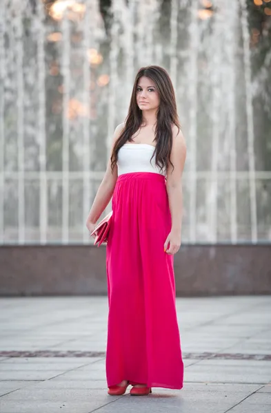 Pełna długość młodych kaukaski kobiece kobieta z długo czerwona spódnica stojący przed fontanną w letnie dni — Zdjęcie stockowe