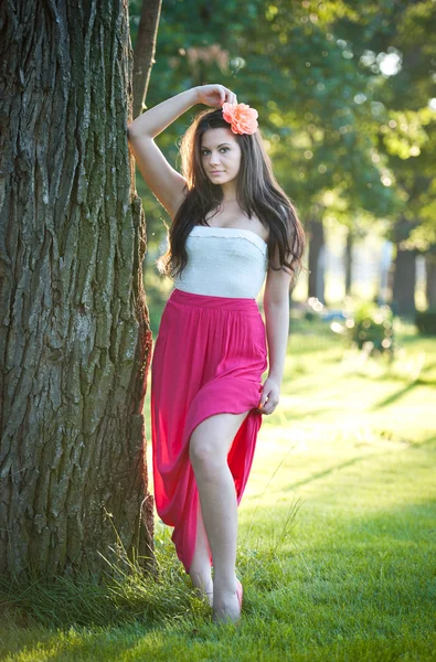 完整长度的年轻白人女性有红色的长裙子站在附近的女人在森林里的树 outdoor.romantic 画像 — 图库照片