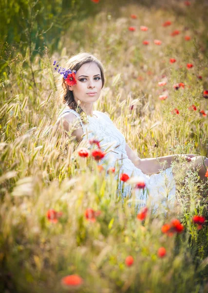 Jovem no campo de trigo dourado.Retrato de menina loira bonita com coroa de flores silvestres.Mulher bonita desfrutando de campo de margarida, menina bonita relaxante ao ar livre, conceito de harmonia — Fotografia de Stock