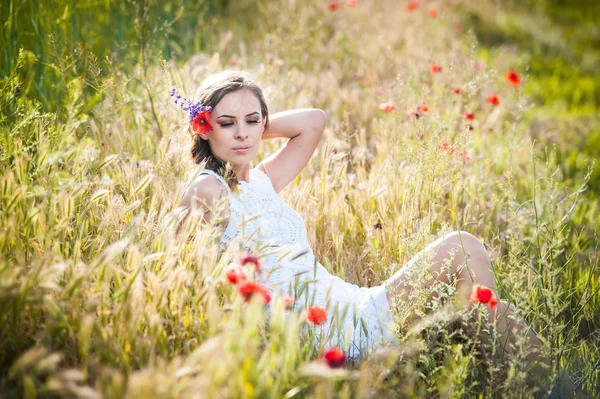 Jovem no campo de trigo dourado.Retrato de menina loira bonita com coroa de flores silvestres.Mulher bonita desfrutando de campo de margarida, menina bonita relaxante ao ar livre, conceito de harmonia — Fotografia de Stock