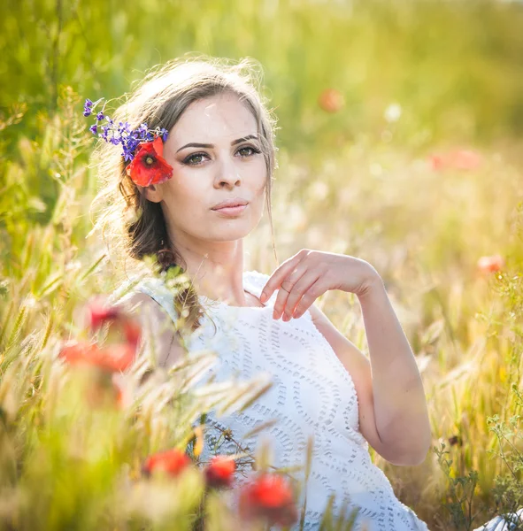 Young girl on golden wheat field.Portrait of beautiful blonde girl with wreath of wild flowers.Beautiful woman enjoying daisy field, pretty girl relaxing outdoor, harmony concept — Stock Photo, Image