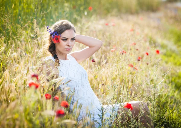 Chica joven en el campo de trigo dorado.Retrato de hermosa chica rubia con corona de flores silvestres.Hermosa mujer disfrutando del campo de margaritas, chica bonita relajante al aire libre, concepto de armonía —  Fotos de Stock
