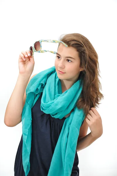 Beautiful teen girl with sunglasses and blue scarf posing. Dynamic image of teen girl with sunglasses on her head isolated on white background — Stock Photo, Image