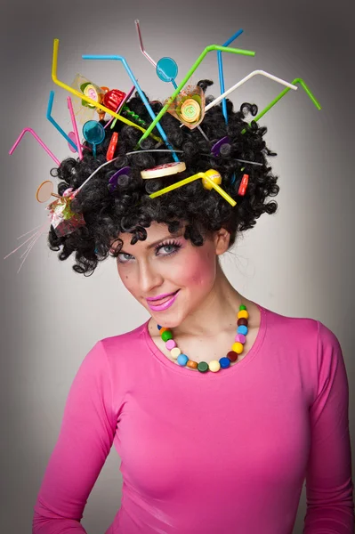 Retrato de una hermosa modelo femenina sobre fondo blanco con piruletas en el cabello.Chica glamurosa con blusa rosa con piruleta y paja de color en el cabello — Foto de Stock