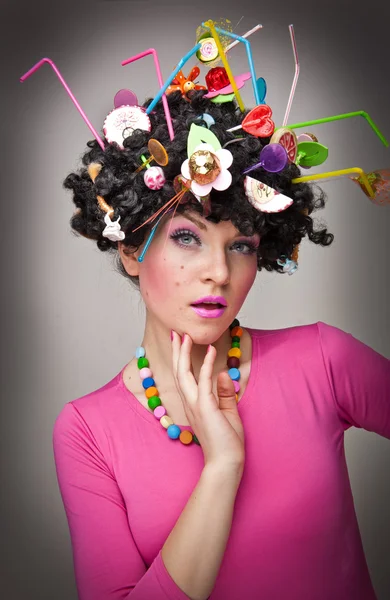 Portrét krásného ženského modelu na bílém pozadí s lízátka v hair.glamorous dívka s růžovou halenku, lízátko a sláma barevné vlasy — Stock fotografie