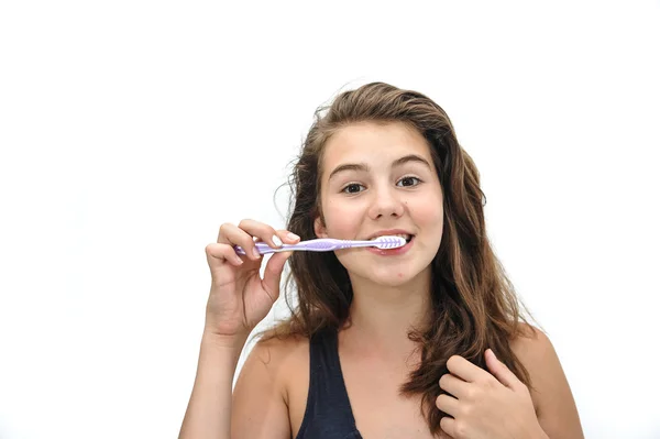 Retrato de uma adolescente sorridente a escovar os dentes isolada no fundo branco. Menina adolescente bonita escovando os dentes sorrindo — Fotografia de Stock