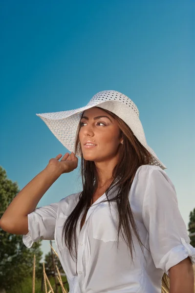 Ritratto di attraente giovane donna in berretto estivo primo piano, contro il cielo azzurro.Donna con cappello da sole — Foto Stock