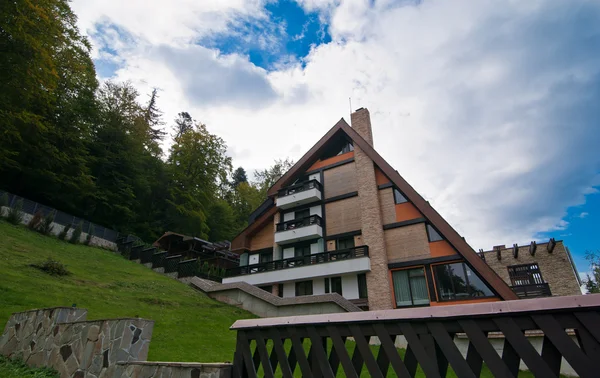 Una cabaña moderna en las montañas. Alojamiento de montaña en primavera. Enorme cabina en la madera — Foto de Stock