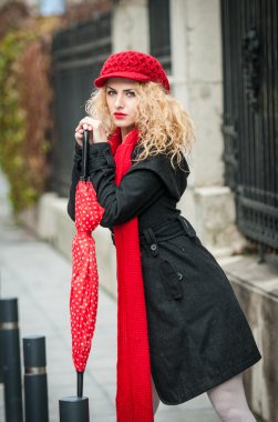 bir kış moda çekici genç kadını vurdu. Kırmızı şemsiye sokakta güzel şık genç kızla