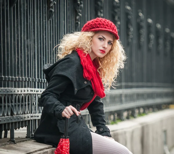 Jolie jeune femme dans un plan de mode d'hiver. Belle jeune fille à la mode avec parapluie rouge dans la rue — Photo