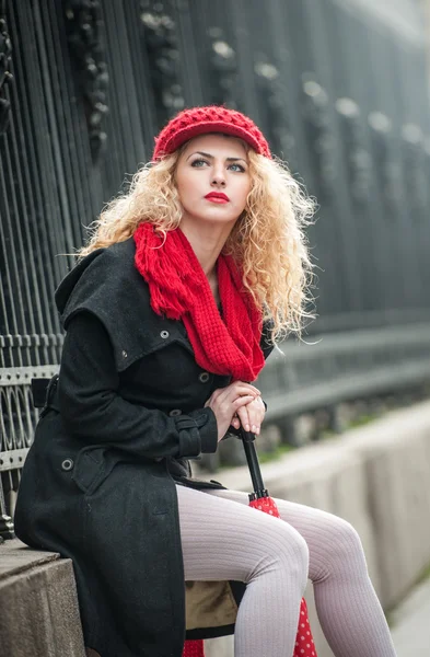 Jolie jeune femme dans un plan de mode d'hiver. Belle jeune fille à la mode avec parapluie rouge dans la rue — Photo