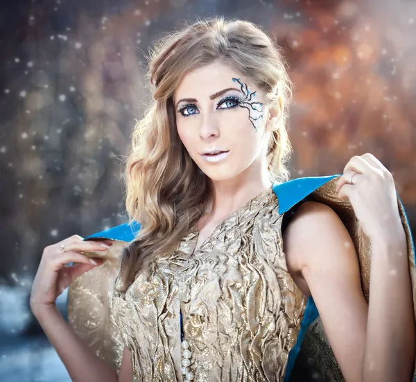 Lovely young lady in elegant dress posing winter scenery, royal look. Fashionable blonde woman with forest in background, outdoor shoot. Glamorous female with long fair hair in nature - princess style — Stock Photo, Image