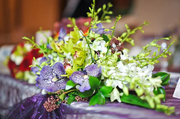Hermoso ramo de flores silvestres, en la mesa. Ramo de boda de flores blancas y malvas. Elegante ramo de bodas en la mesa del restaurante. Arreglos florales en detalle ceremonia de boda . —  Fotos de Stock