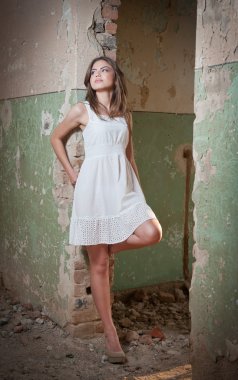 güzel bir kız moda duvar eski yakın poz. oldukça genç bir kadın kılığında bir duvar döşeme. şeffaf, beyaz, kısa bir elbise ile çok çekici sarışın kız. romantik genç bir kadın kılığında