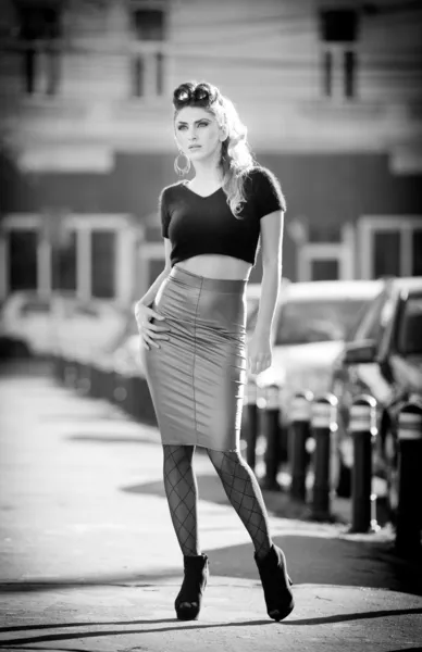 Attraktive junge Frau in urbaner Mode. schöne modische junge Mädchen mit eng anliegenden Kleidern und langen Beinen, die auf der Straße posieren. elegante blonde Frau posiert in urbaner Landschaft — Stockfoto