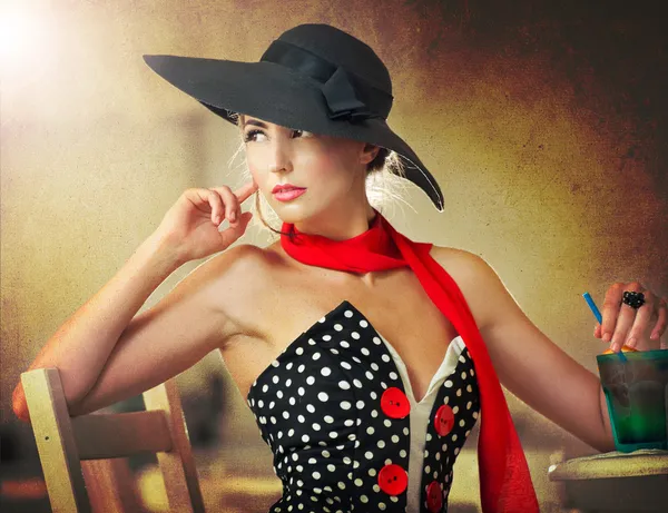 Señorita atractiva de moda con sombrero negro y bufanda roja sentado en la silla en el restaurante, tiro interior. Mujer joven posando en un paisaje elegante. Foto de arte de mujer sensual elegante, estilo vintage —  Fotos de Stock