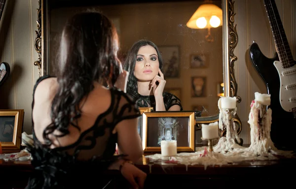 Hermosa mujer sexy en vestido de encaje negro en el paisaje vintage con velas. Retrato de chica morena de pelo largo posando en interiores de lujo. Atractiva joven mujer de moda con maquillaje creativo —  Fotos de Stock