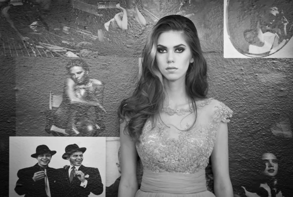 Schöne Brünette in elegantem Spitzenkleid posiert in einer Vintage-Szene. junge sinnliche modische Frau auf Plakaten an der Wand. attraktive Mädchen mit langen Haaren, Innenaufnahmen — Stockfoto