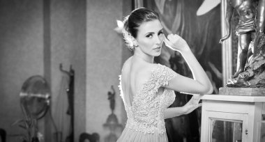 bağbozumu sahne beyaz dantel elbiseli güzel seksi kadın. yaratıcı saçlı esmer genç kadın portre kapalı lüks içinde poz kesti. çekici bir genç kadın moda, siyah ve beyaz fotoğraf