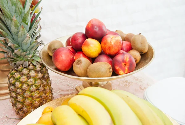 Fruits arrangement. Fresh various fruits elegant decoration. Assortment of exotic fruits. Multicolored fruits. Wedding decoration with fruits on restaurant table, pineapple, bananas, nectarines, kiwi — Stock Photo, Image