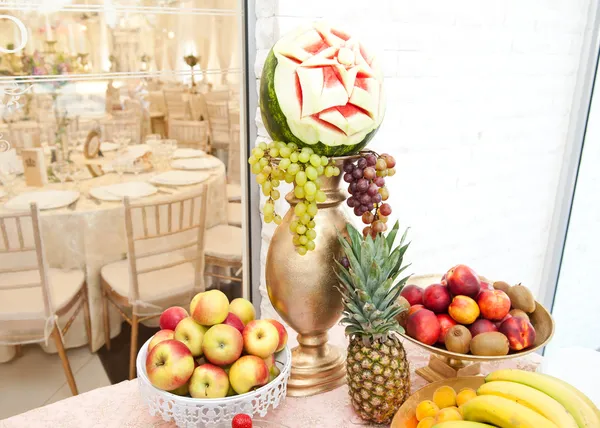 Arreglo de frutas. Fresco varias frutas decoración elegante. Surtido de frutas exóticas. Frutas multicolores. Decoración de la boda con frutas en la mesa del restaurante, piña, plátanos, nectarinas, kiwi — Foto de Stock