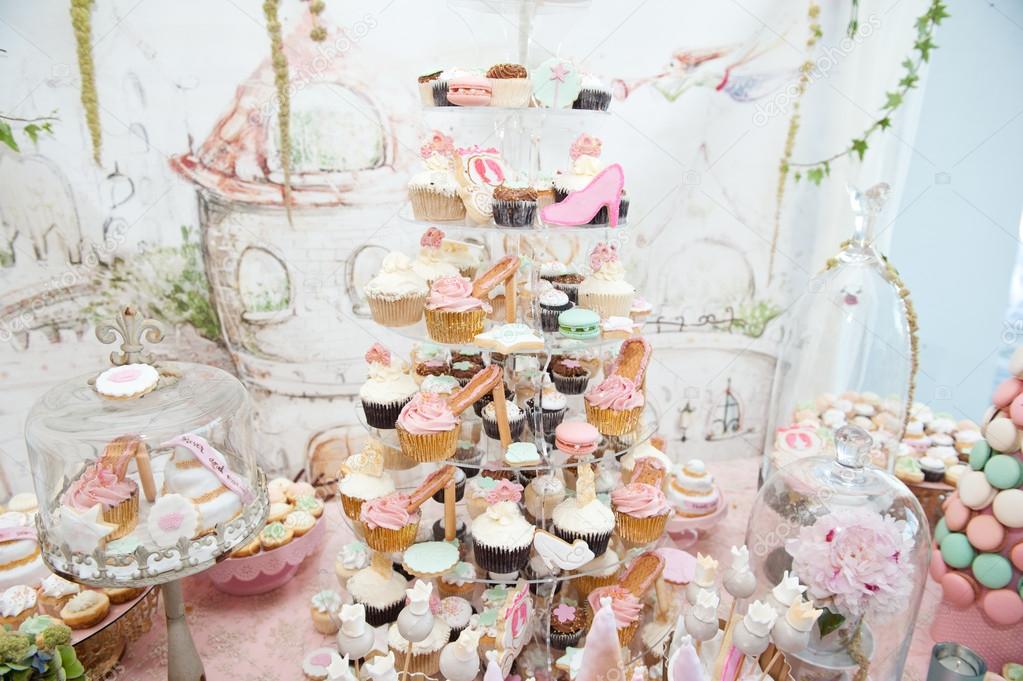 Wedding decoration with pastel colored cupcakes, meringues, muffins and ...