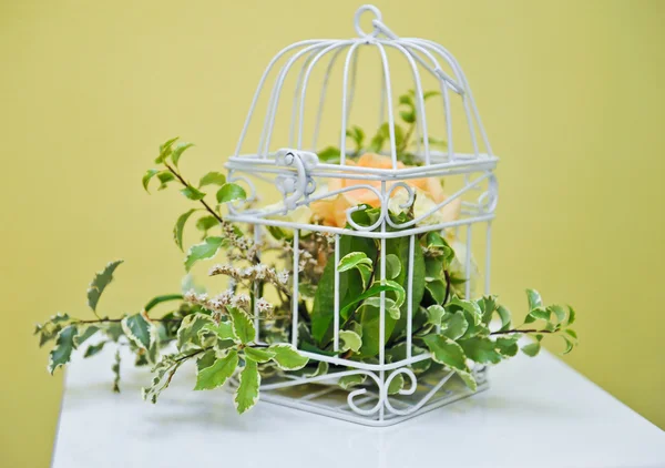 Decoración de brillante flor de color naranja y verde en jaula blanca. decoración de la boda con jaula de aves y flores. Flor en hermosa jaula de aves vintage. Decoración de la boda idea . — Foto de Stock