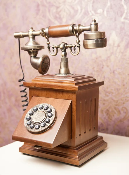 Old wooden phone. Vintage wooden telephone on white table. Retro phone.