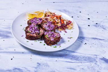 Lahana salatası, kırmızı soğan ve limonla süslenmiş Yunanca ünlü kokoretsi tabağı.